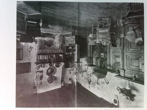 Watercolour. A woman wearing a long white dress stands near a curved alcove under a rounded arch. A window-lined alcove is to our right. A monogram of LAT is inlaid in the gleaming marble floor. The scene is painted in grey washes.