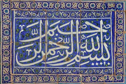 Tiles. A panel of six tiles, three across by two high, are painted with Arabic script in white against vivid blue. Two leafy and floral borders surround the central design.