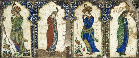 Tiles. Each of four vertical rectangular tiles has a person standing under a multifoil arch, which has an inwards-facing scalloped edge. The arches are cobalt blue and the backgrounds white. Each person wears long garments and headcoverings.