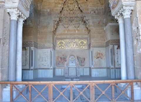 Architecture. Two pairs of columns frame a view into an arched space with a honeycomb vault. The spaces below are decorated with ave mosaics, frescoes, and tiles. Water used to pour from a fountain under the vault into a lowercase t shaped channel along the floor.