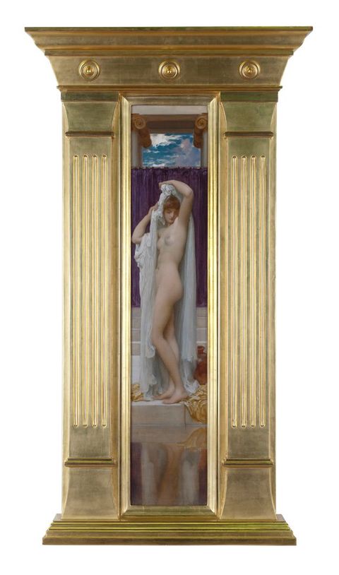 Painting. A pale-skinned, nude woman stands by a pool of water, her arms lifted over her head as she removes a long white garment. The canvas is strikingly narrow and is set in a substantial gold frame with columns nearly as wide as the painting to each side.