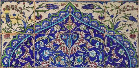 Tiles. Eight tiles, four across and two down, are painted with a pointed arch filled with a leafy pattern in brilliant blue, green, muted red, and white. The corners above the arch have blue and red flowers against a cream-white background.